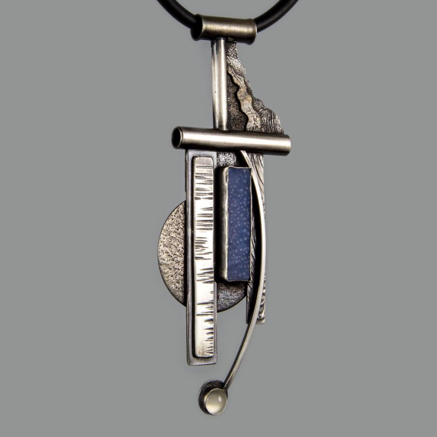 Geometric pendant necklace on gray.