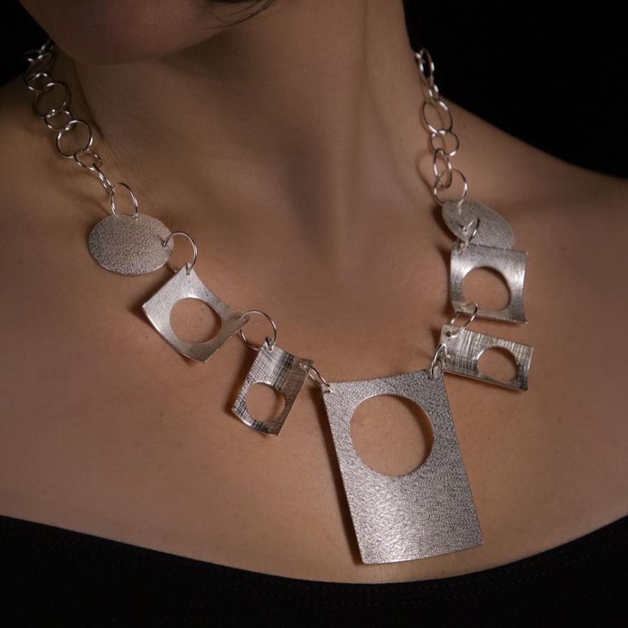 Woman wearing a silver statement necklace.