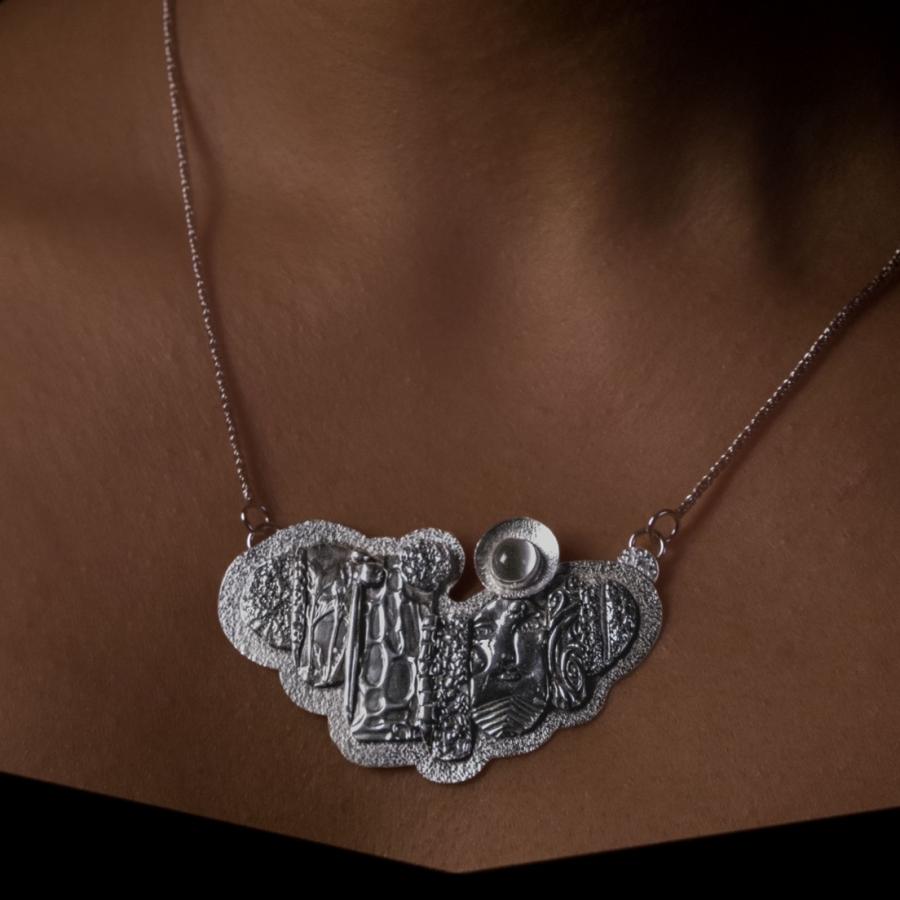 Model wearing a sculptured silver pendant