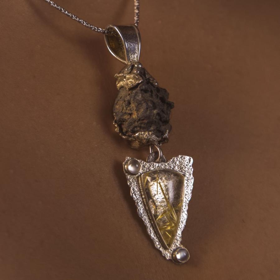 Woman wearing a unique silver pendant with multiple stones