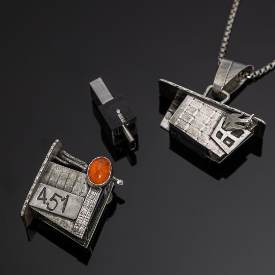 Silver building pendant with orange stone showing USB drive