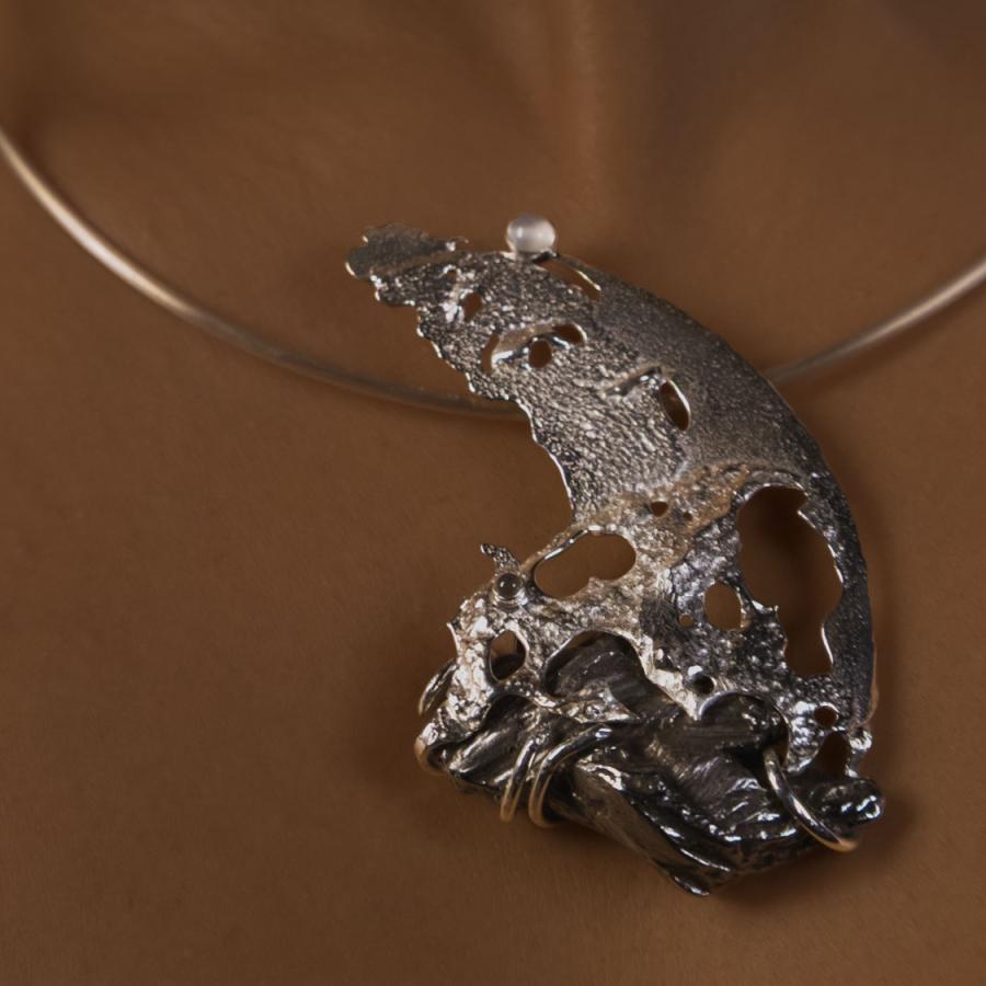 Model wearing a silver and meteorite pendant