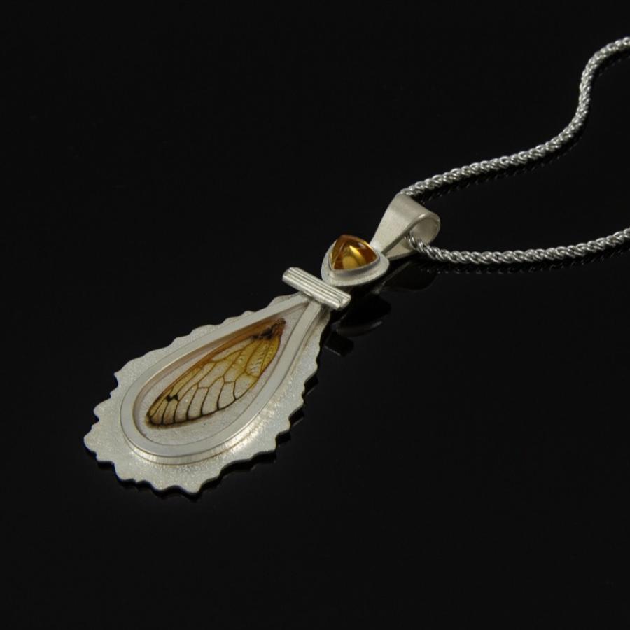 Silver pendant with yellow stone and insect wing