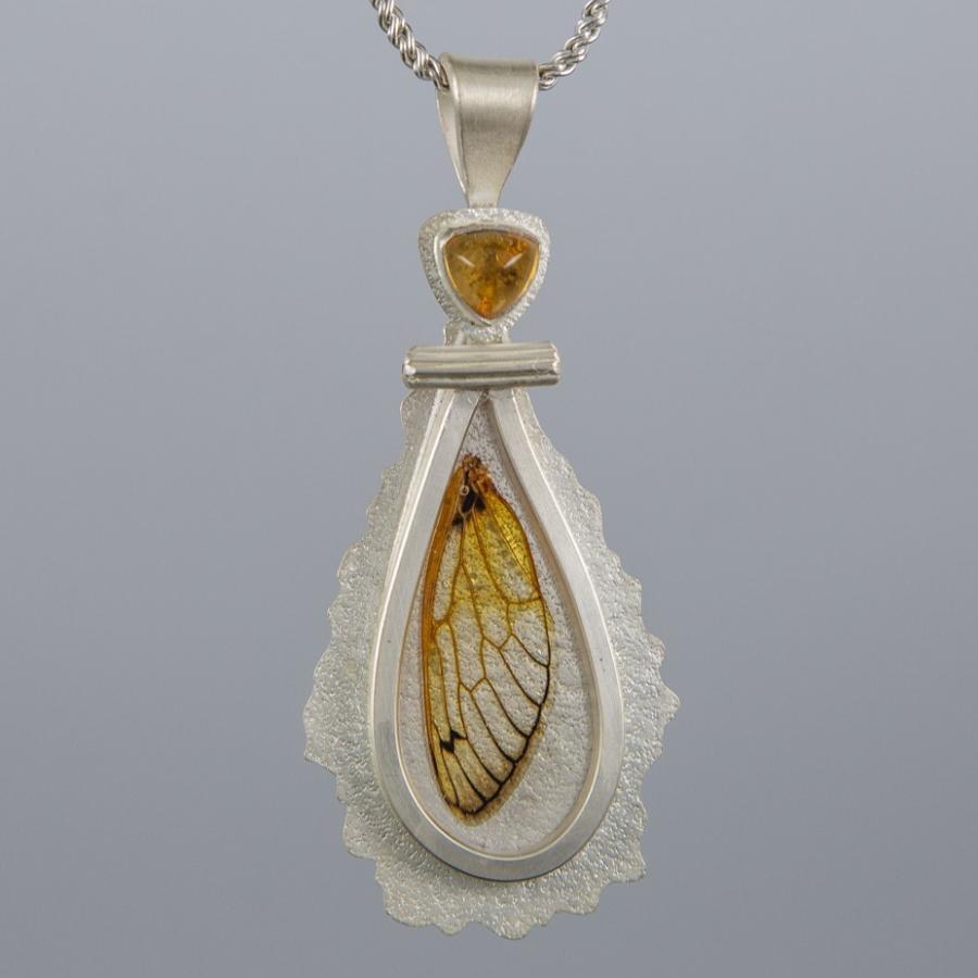Silver pendant with yellow stone and insect wing