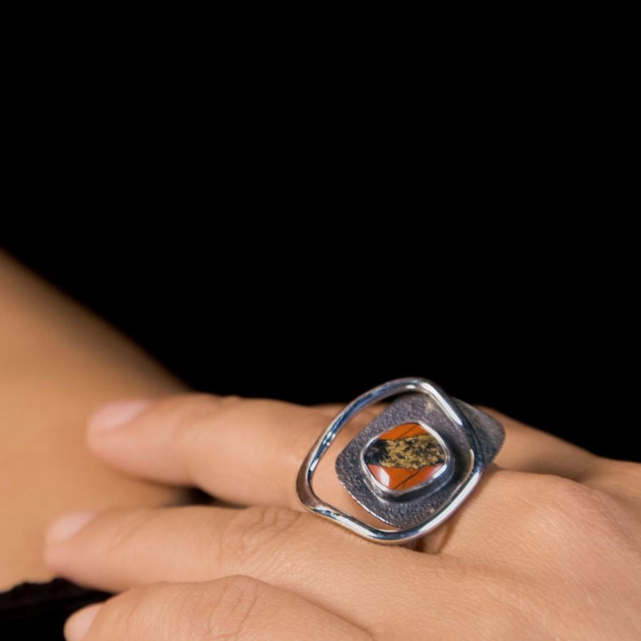 Model wearing a silver ring with a red stone