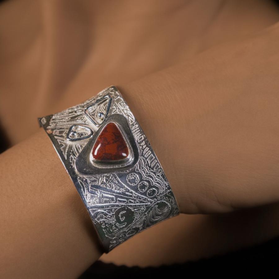 Silver bracelet with a red stone worn by a model