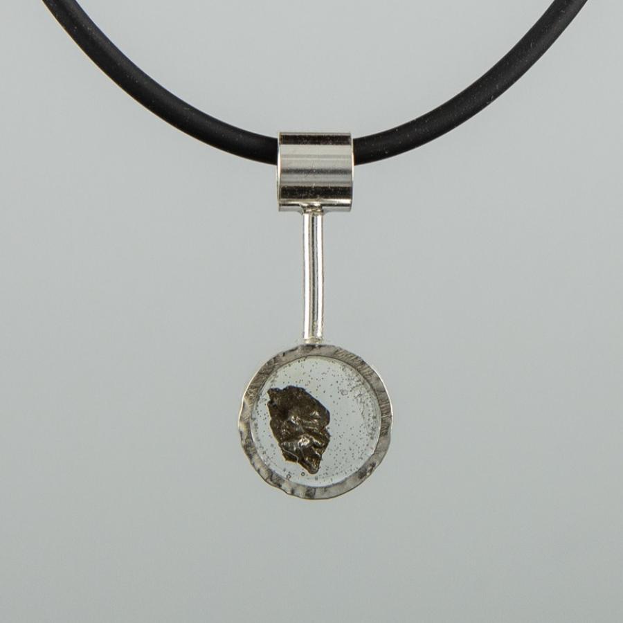 Circular silver pendant with suspended black stone