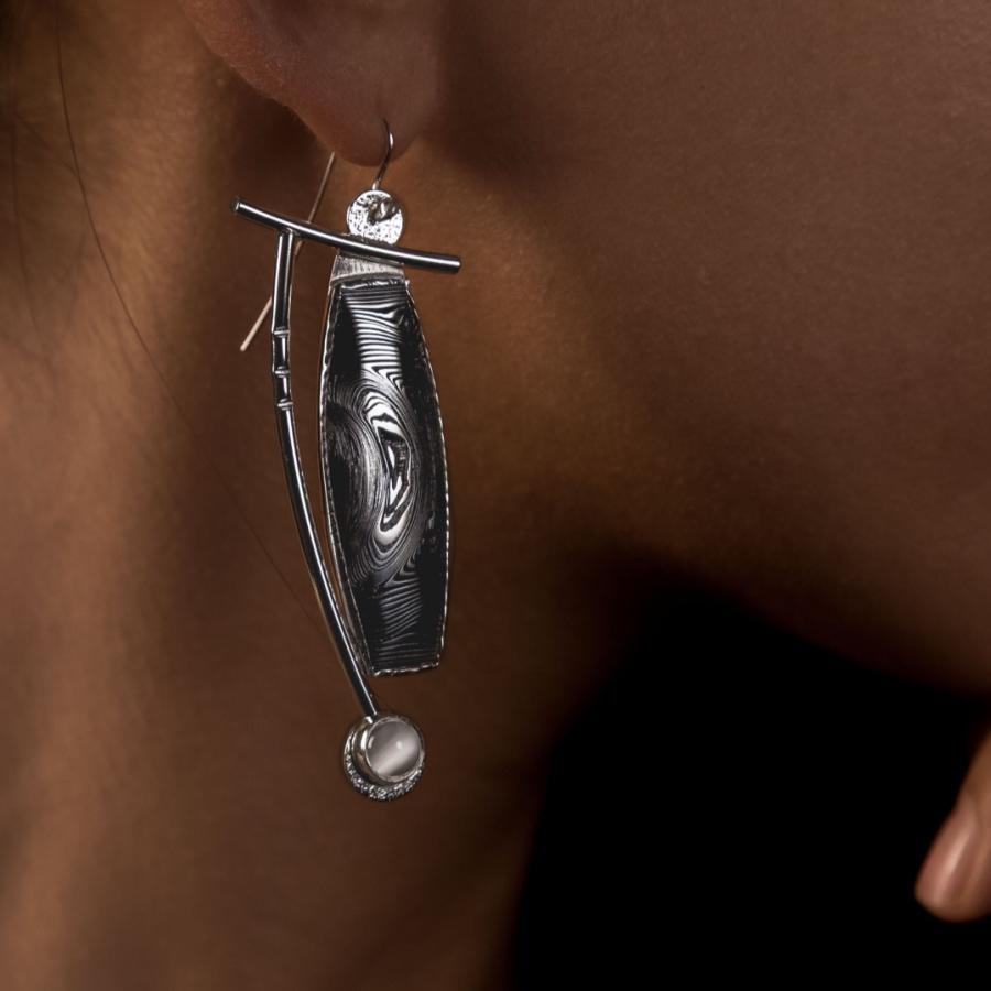 Silver and black earrings on a model