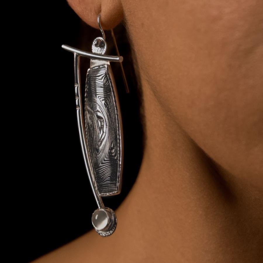 Silver and black earrings on a model