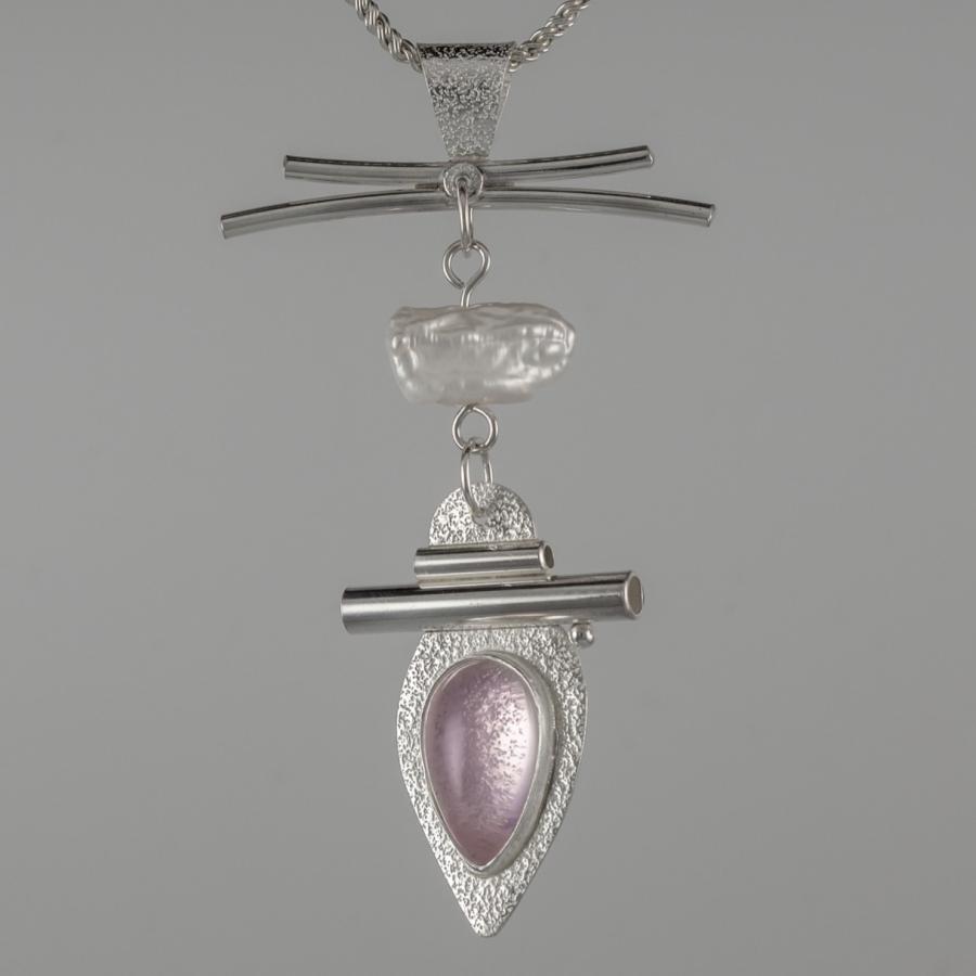 Silver pendant with a pink stone and pearl.