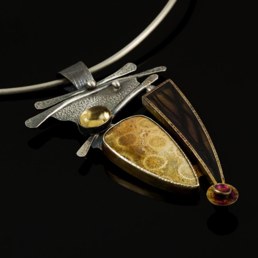 Silver pendant with yellow stones and a black feature