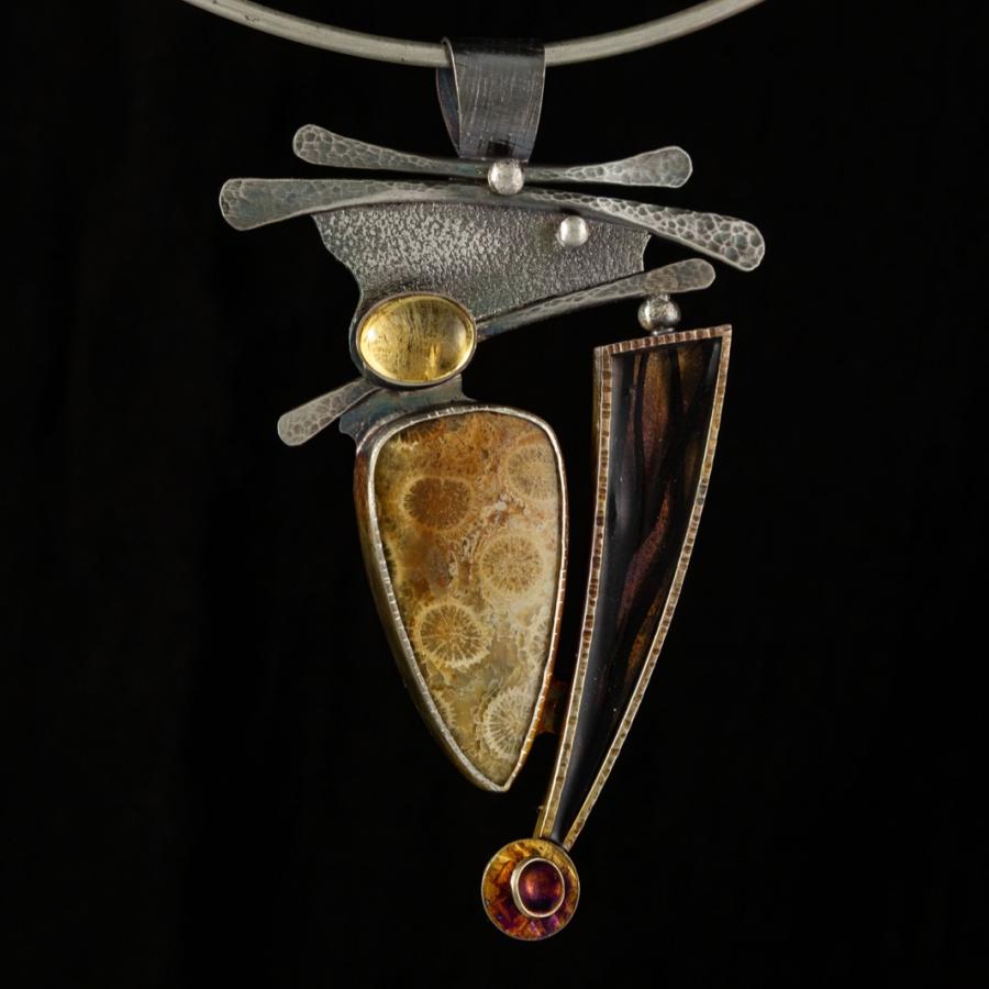 Silver pendant with yellow stones and a black feature