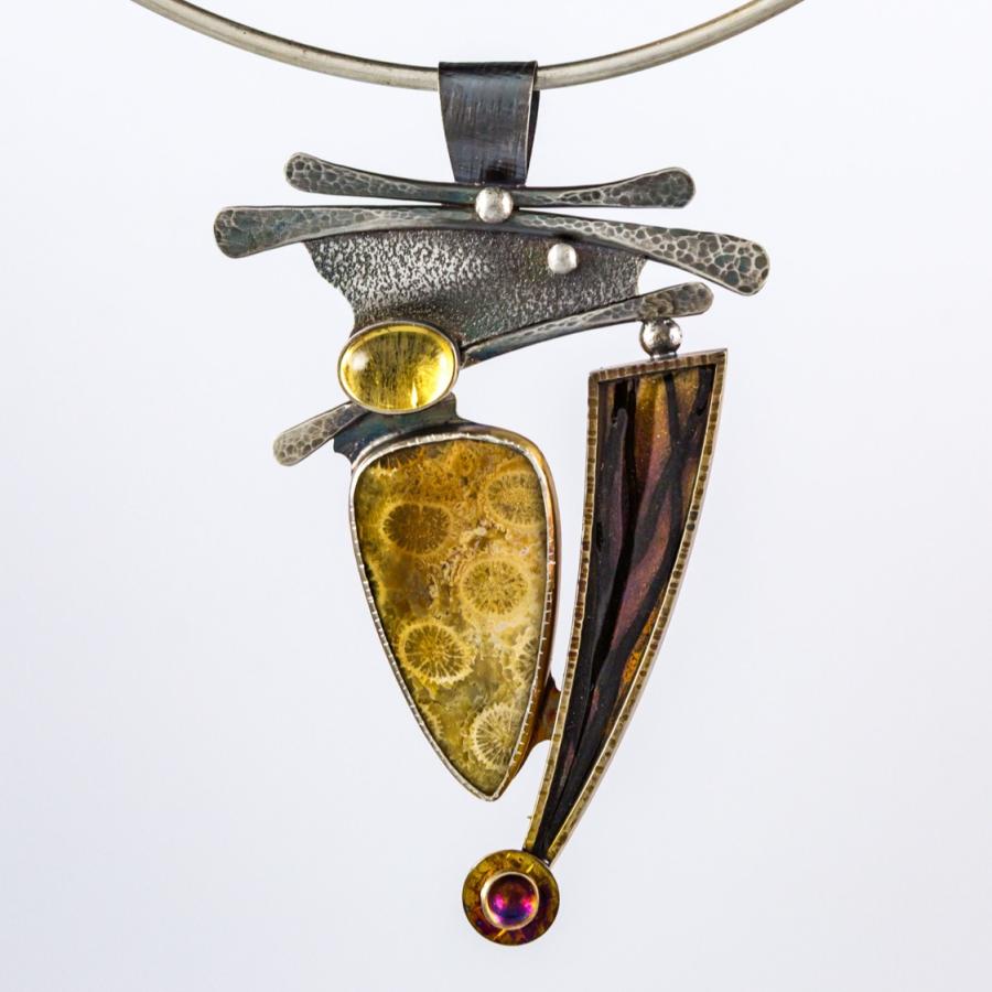 Silver pendant with yellow stones and a black feature