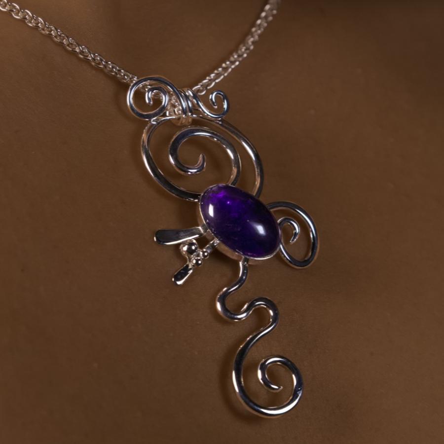 Model wearing a silver pendant with purple stone