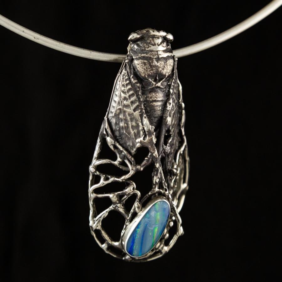 Insect cast in silver with a blue stone