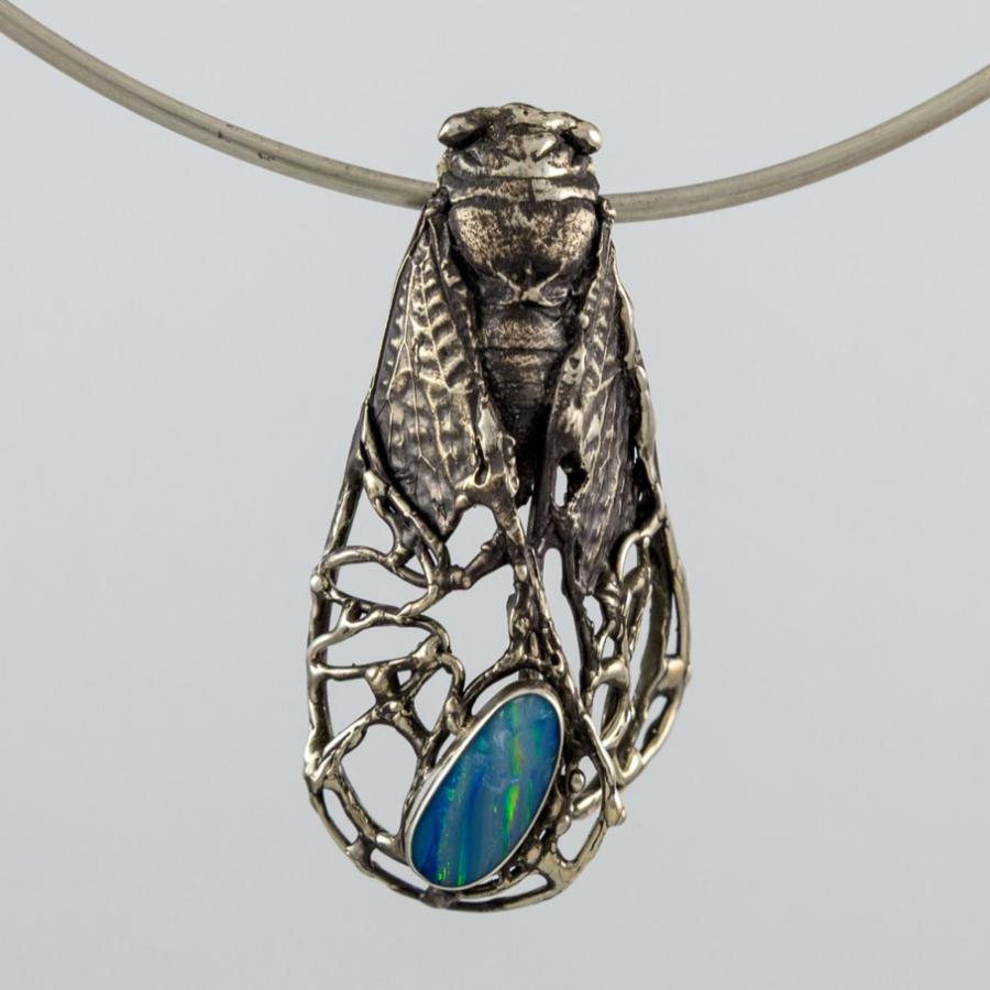 Insect cast in silver with a blue stone
