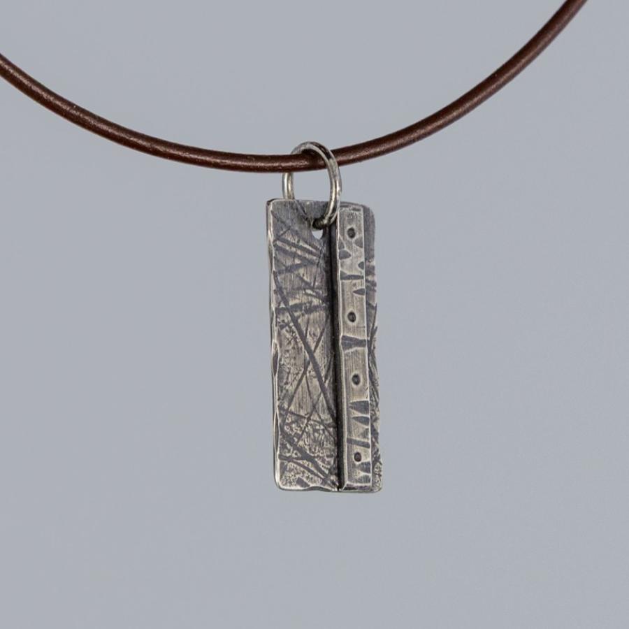 Silver pendant on brown leather cord