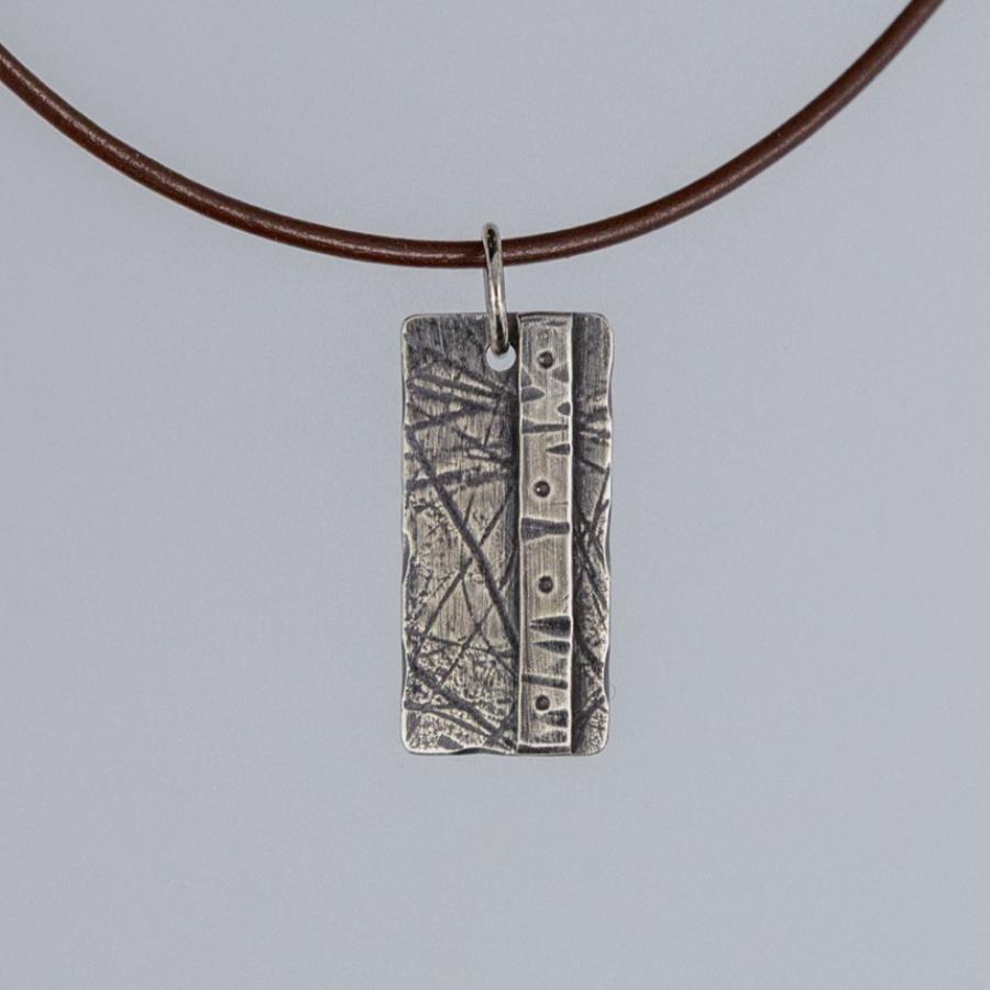 Silver pendant on brown leather cord