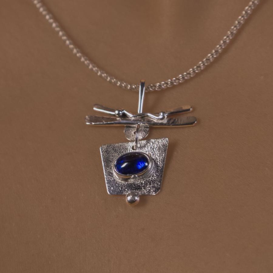 Model wearing a silver pendant with blue stone