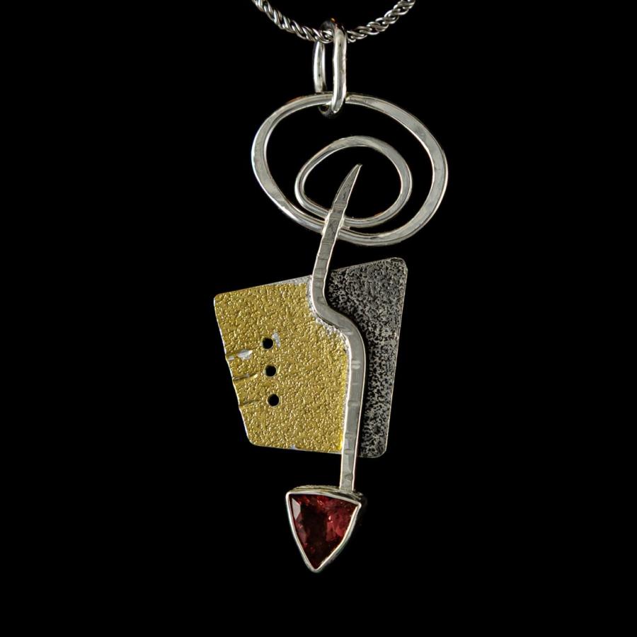 Silver and gold pendant with a red triangular stone