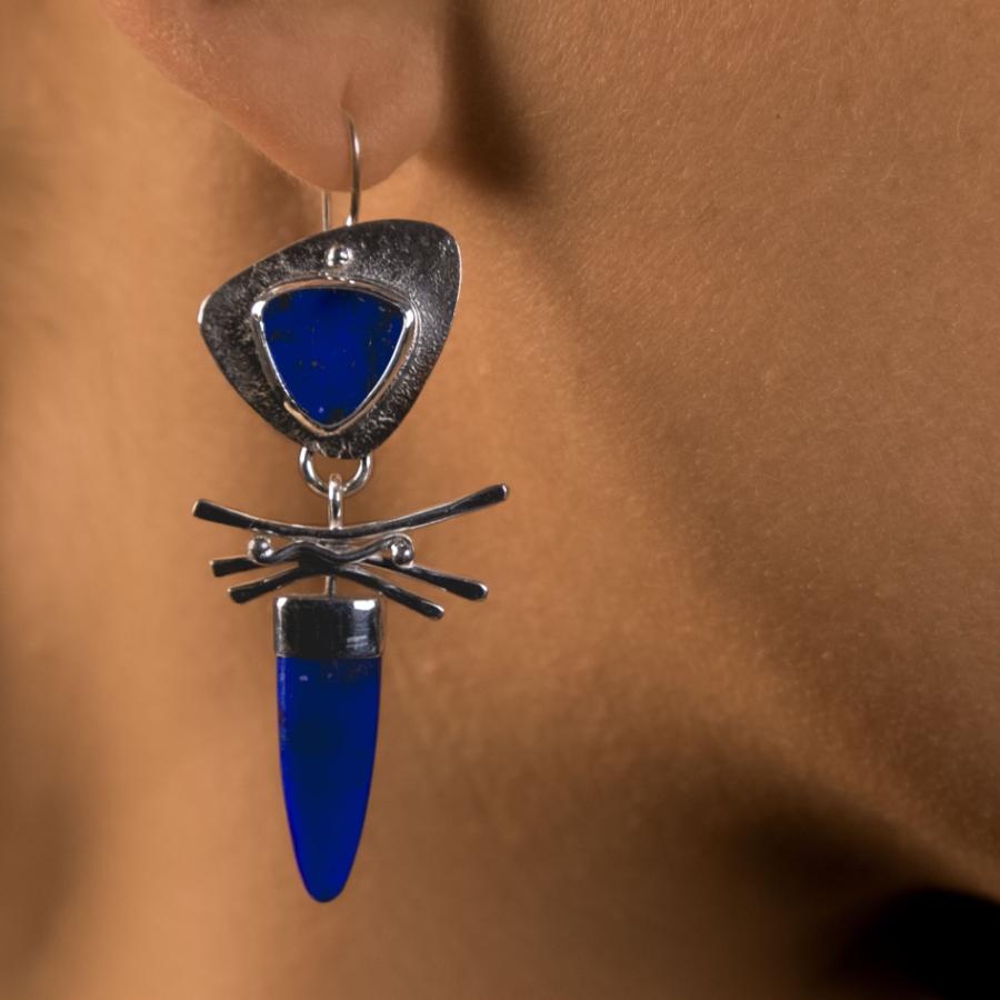 Model wearing a silver earring with blue stones