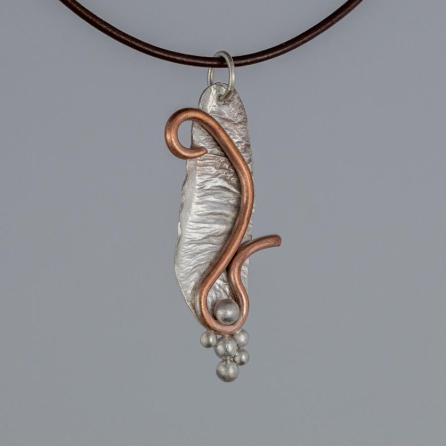 Silver and copper pendant on brown leather cord
