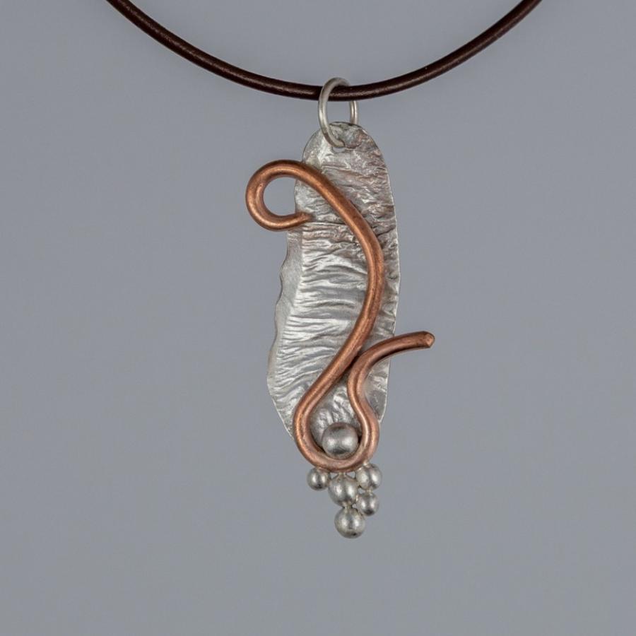 Silver and copper pendant on brown leather cord