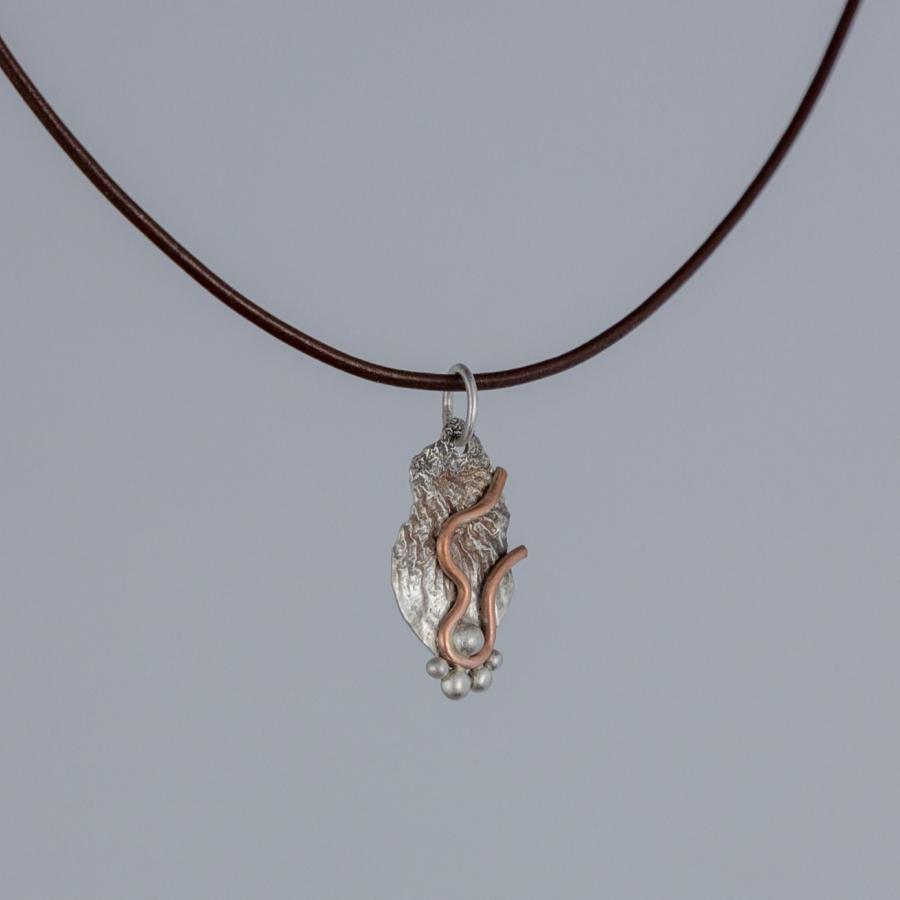 Silver and copper pendant on brown leather cord