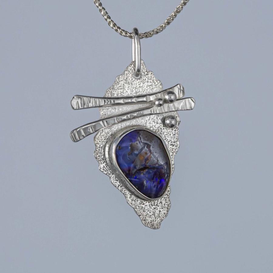 Silver pendant with a dark blue stone
