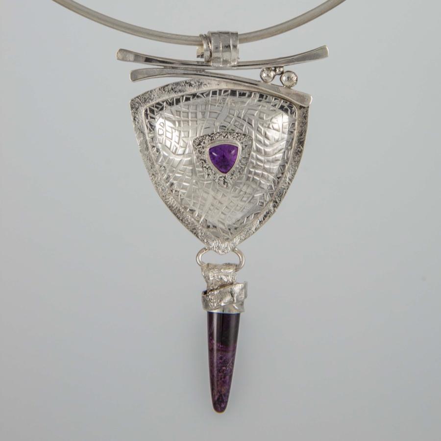 A trillion shaped pendant with a dangling purple stone.