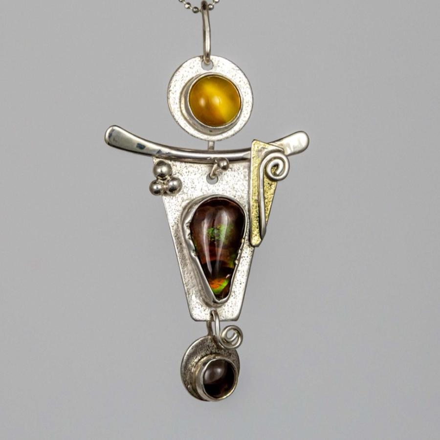 Abstract silver pendant necklace with amber and opal stones against a white background.