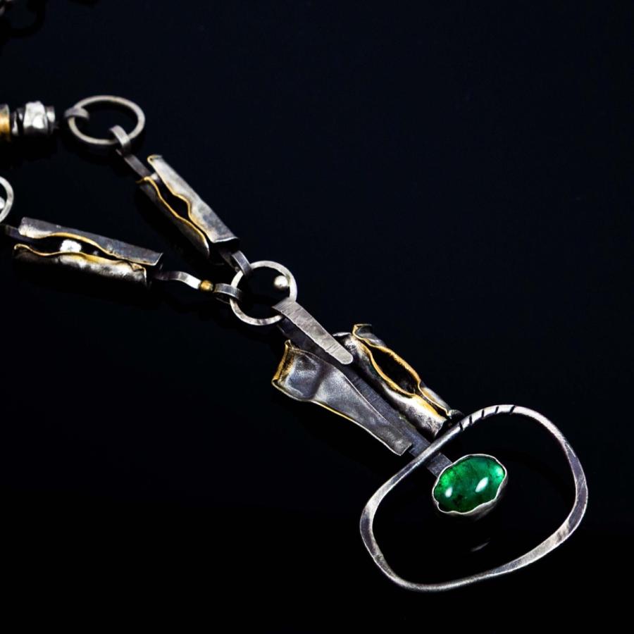 Silver and gold link necklace with a central green stone pendant.