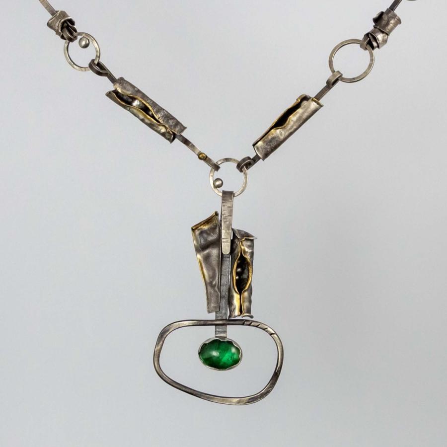 Silver and gold link necklace with a central green stone pendant.