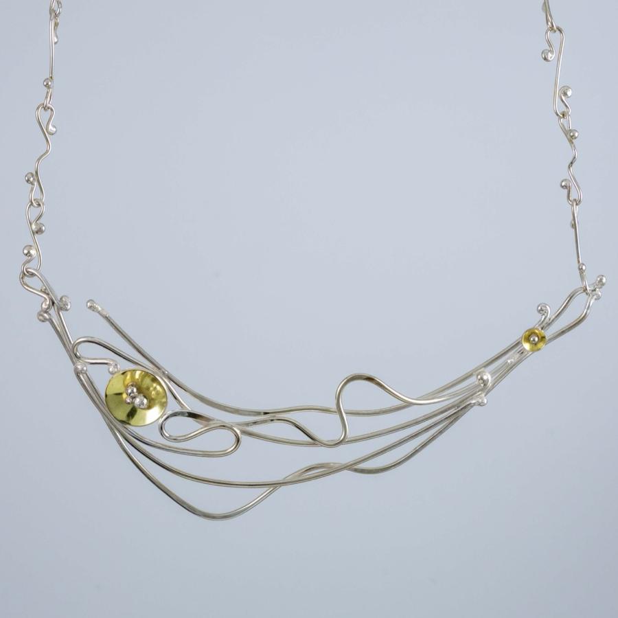 Silver wire necklace with organic, flowing lines and two small gold circular accents.