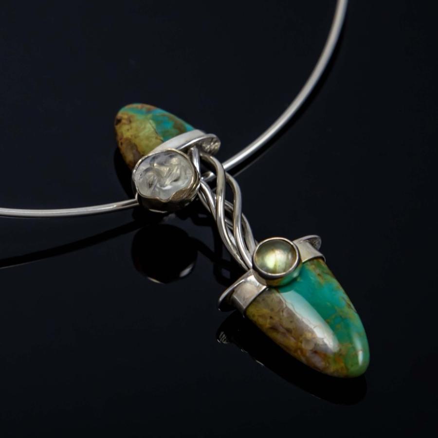 Photograph of a silver necklace featuring two turquoise teardrop stones and a small moonstone.