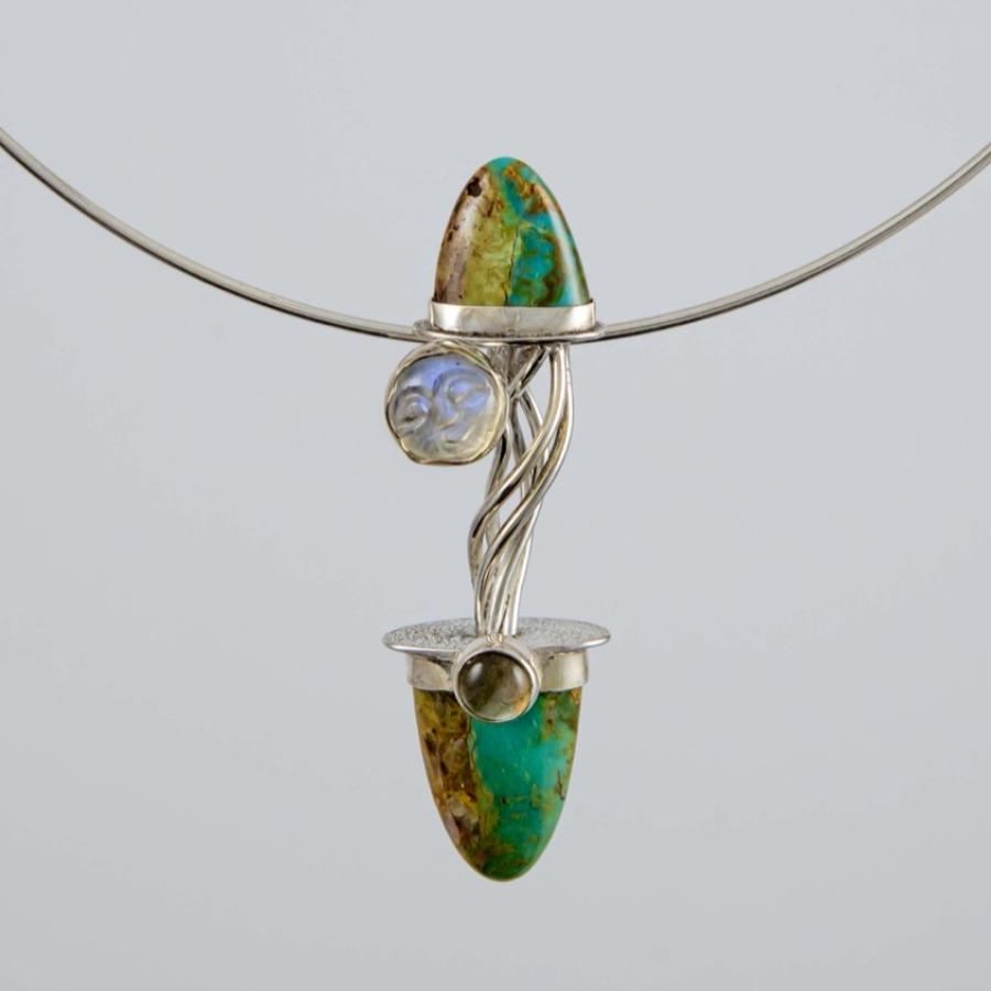 Photograph of a silver necklace featuring two turquoise teardrop stones and a small moonstone.