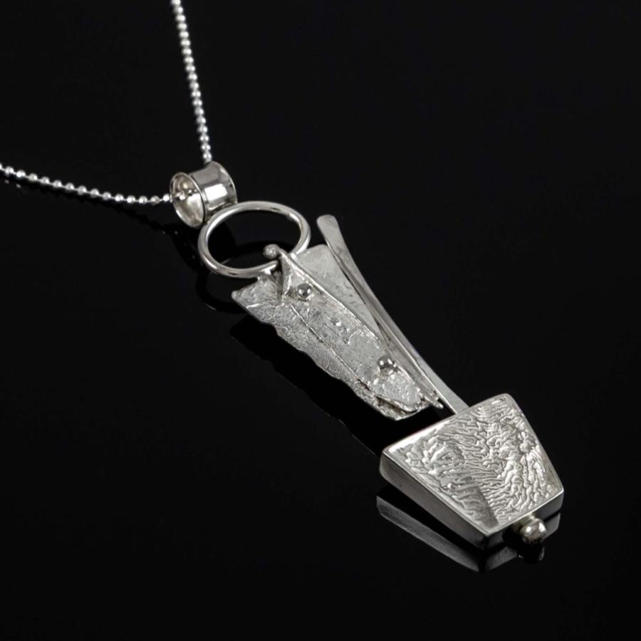 Silver textured pendant necklace on a black background.