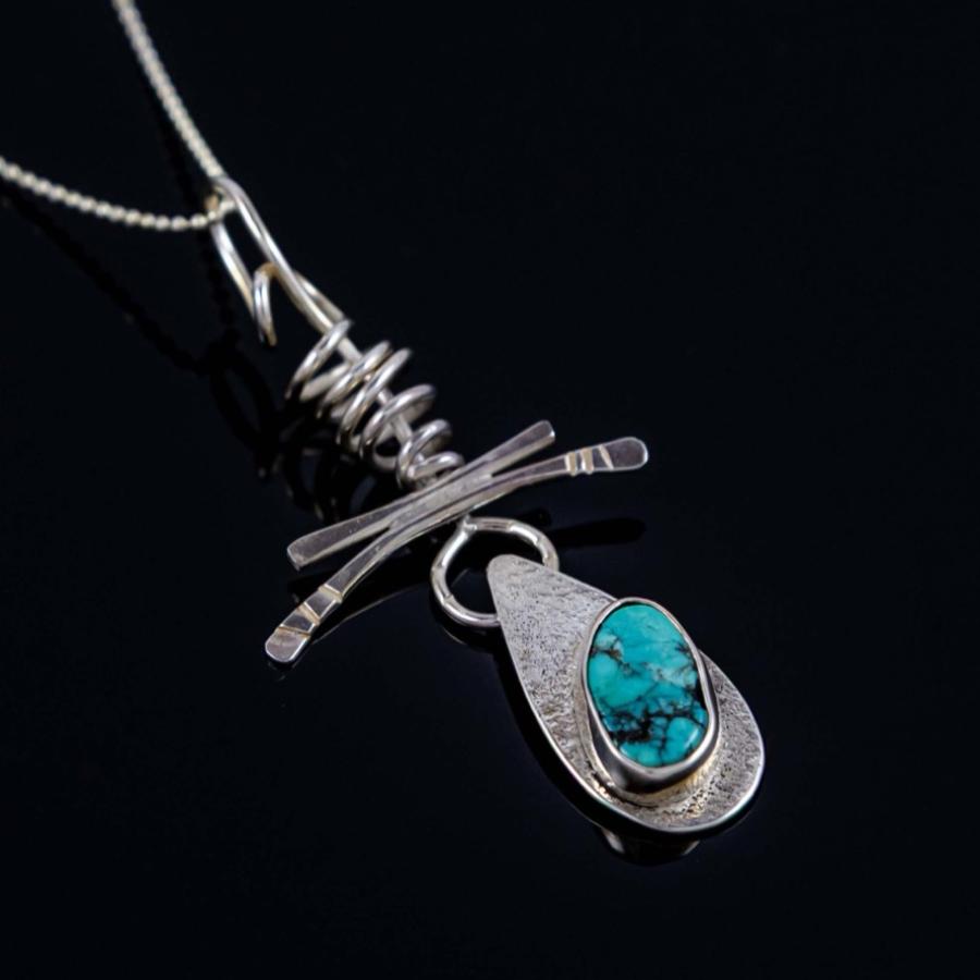 Silver necklace with a teardrop-shaped turquoise pendant.