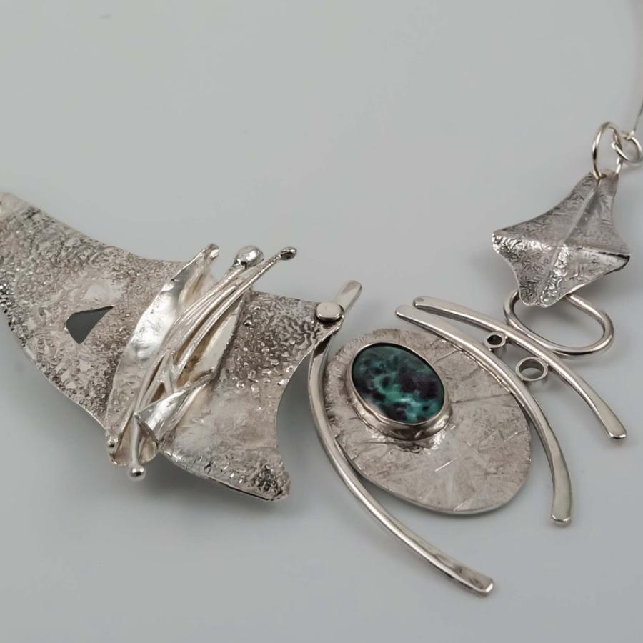 Photograph of an asymmetrical sterling silver necklace with a single oval stone.