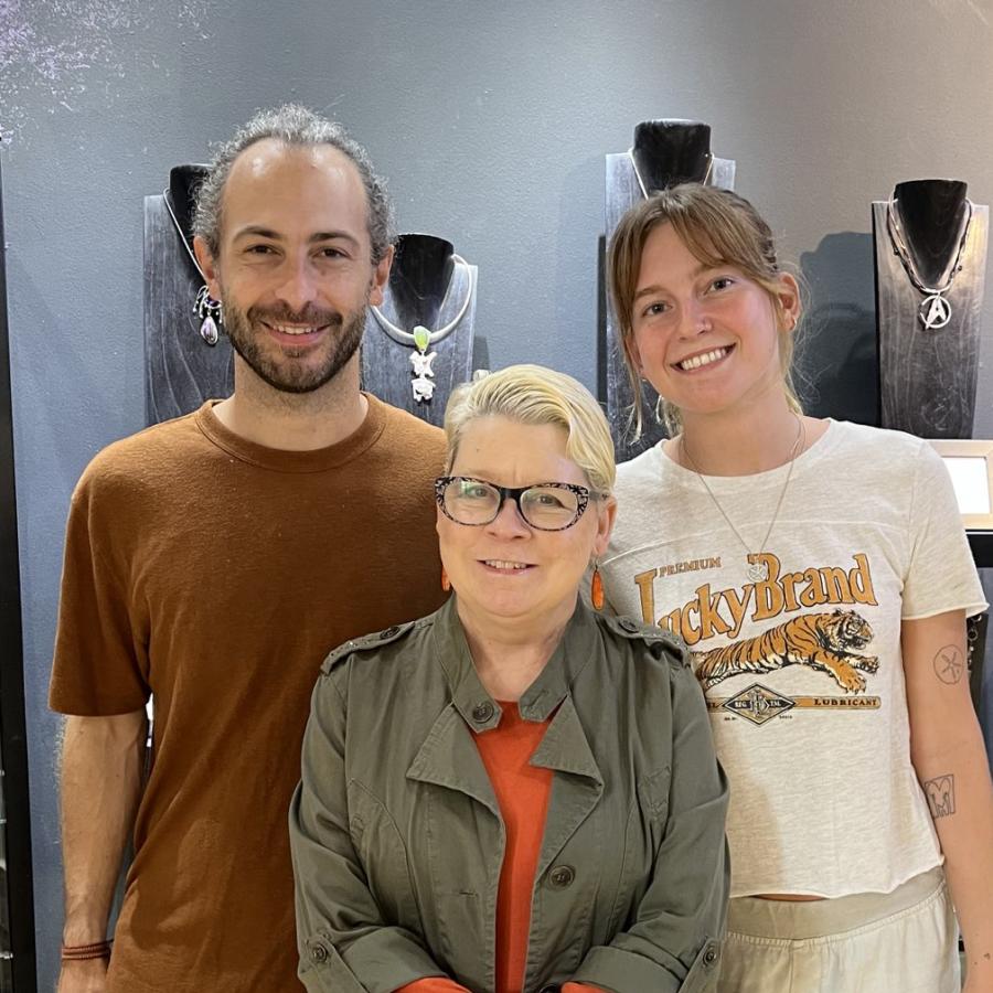 Photograph of three people posing in a jewelry store.