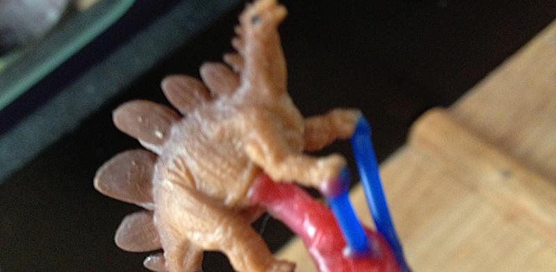 A little plastic dinosaur on was sprue for casting.