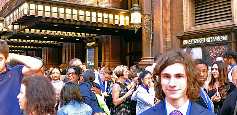 Louis in a suit in front of Carnegie Hall