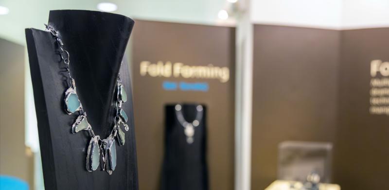 Necklace on a stand in jewelry exhibit.