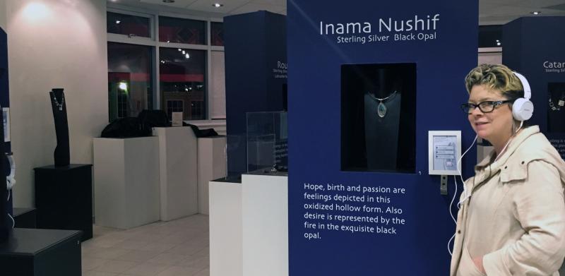 Person in jewelry exhibit with headphones.