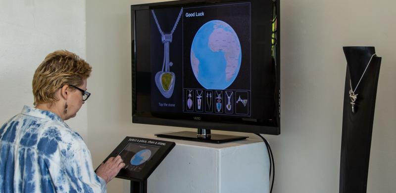 Person interacts with display about jewelry.