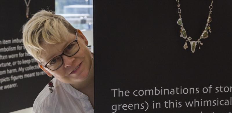 Woman peak out from behind a art installation display