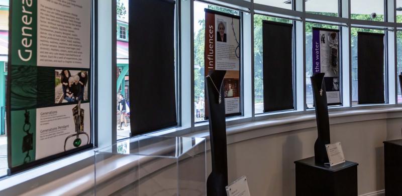 Informational posters and pedestals with hanging displays in a sunlit museum gallery.
