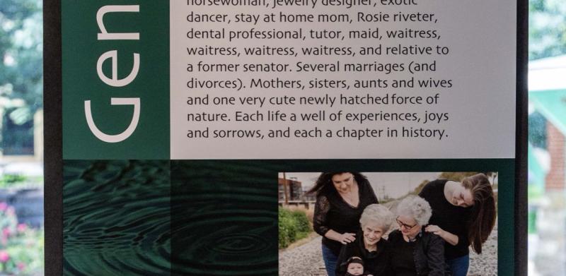 Informational display titled "Generations" with text, a family photo, and a pendant illustration.