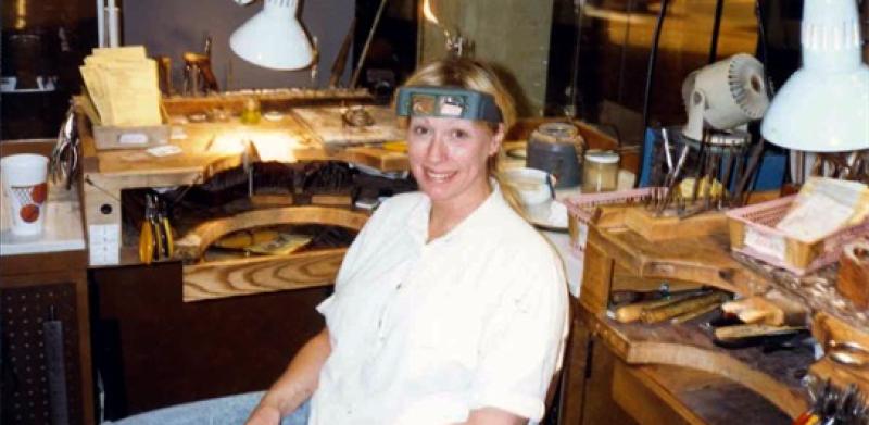 A woman at a jeweler's workbench