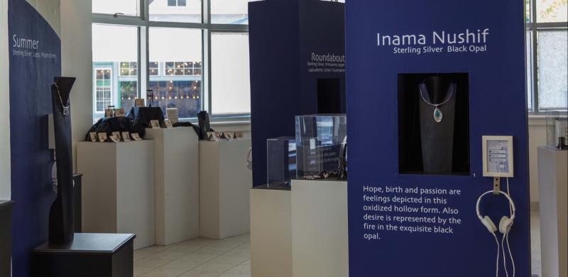 Photograph of a jewelry exhibition display with blue pillars and pedestals.